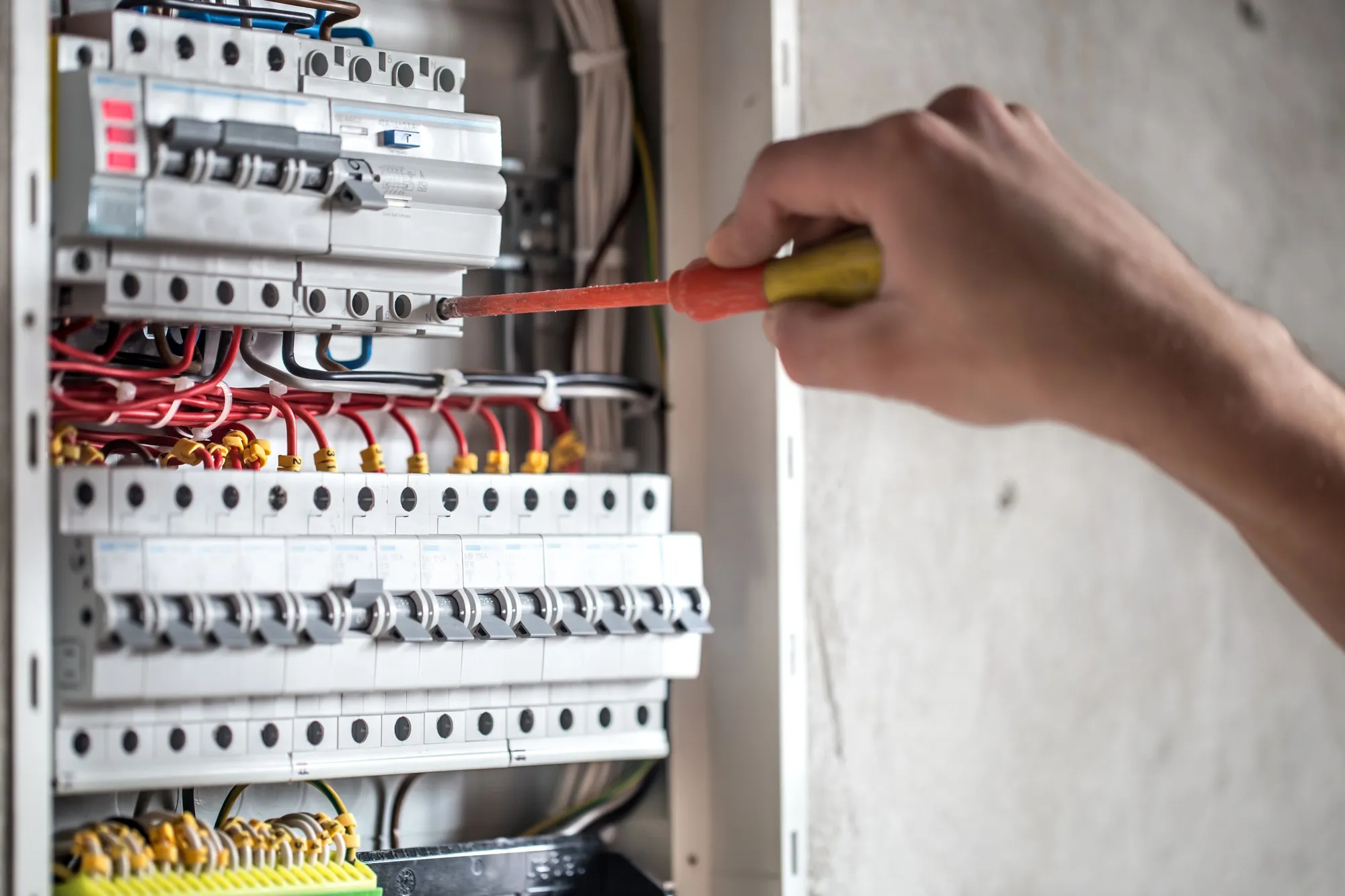 L'uomo, un tecnico elettrico che lavora in un quadro elettrico con fusibili. Installazione e collegamento.