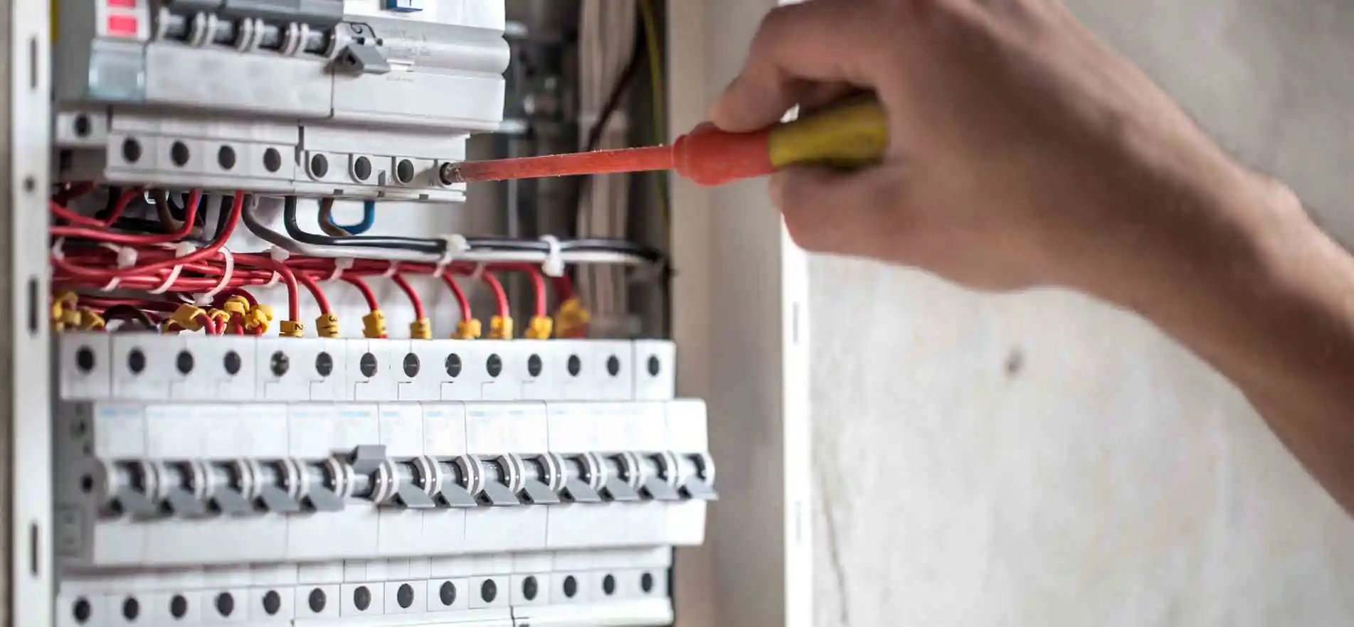 L'uomo, un tecnico elettrico che lavora in un quadro elettrico con fusibili. Installazione e collegamento.